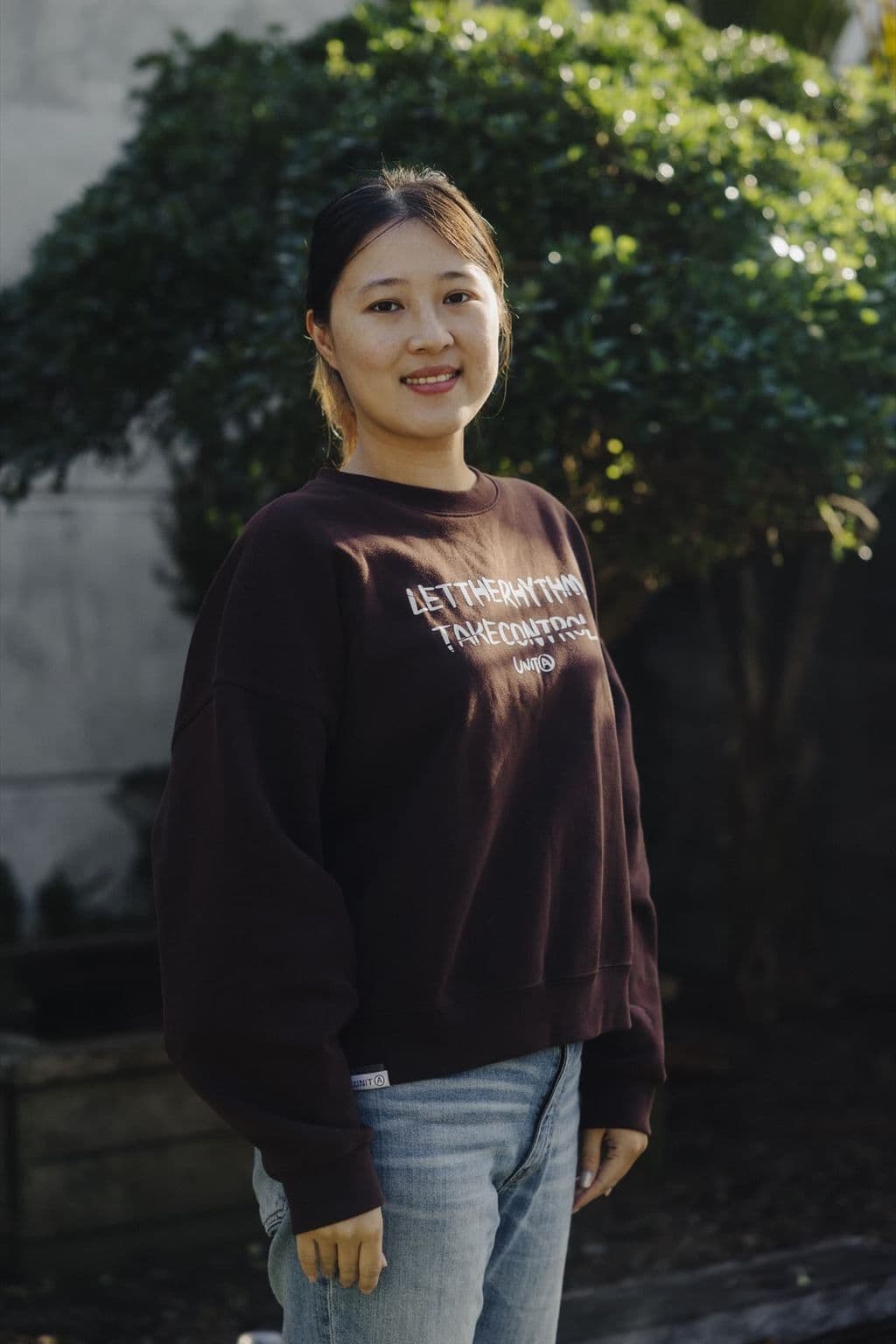 Triton Montessori team member in a centre sweatshirt outdoors