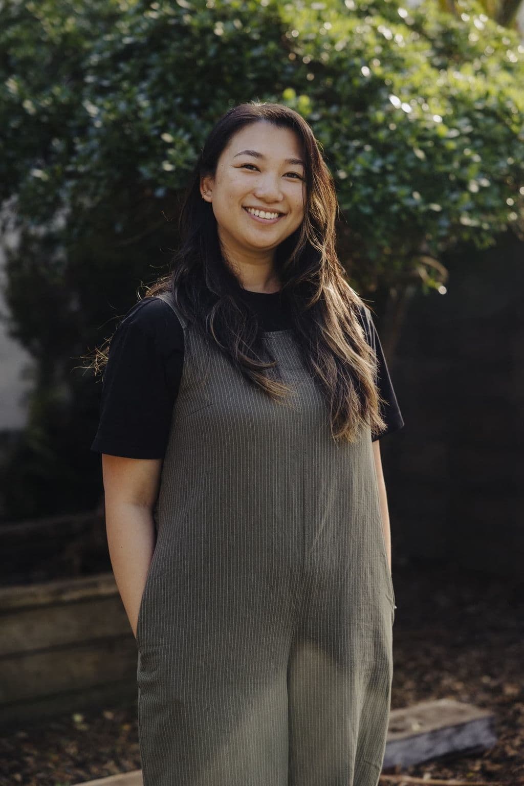 Triton Montessori team member in a grey pinafore photographed outdoors