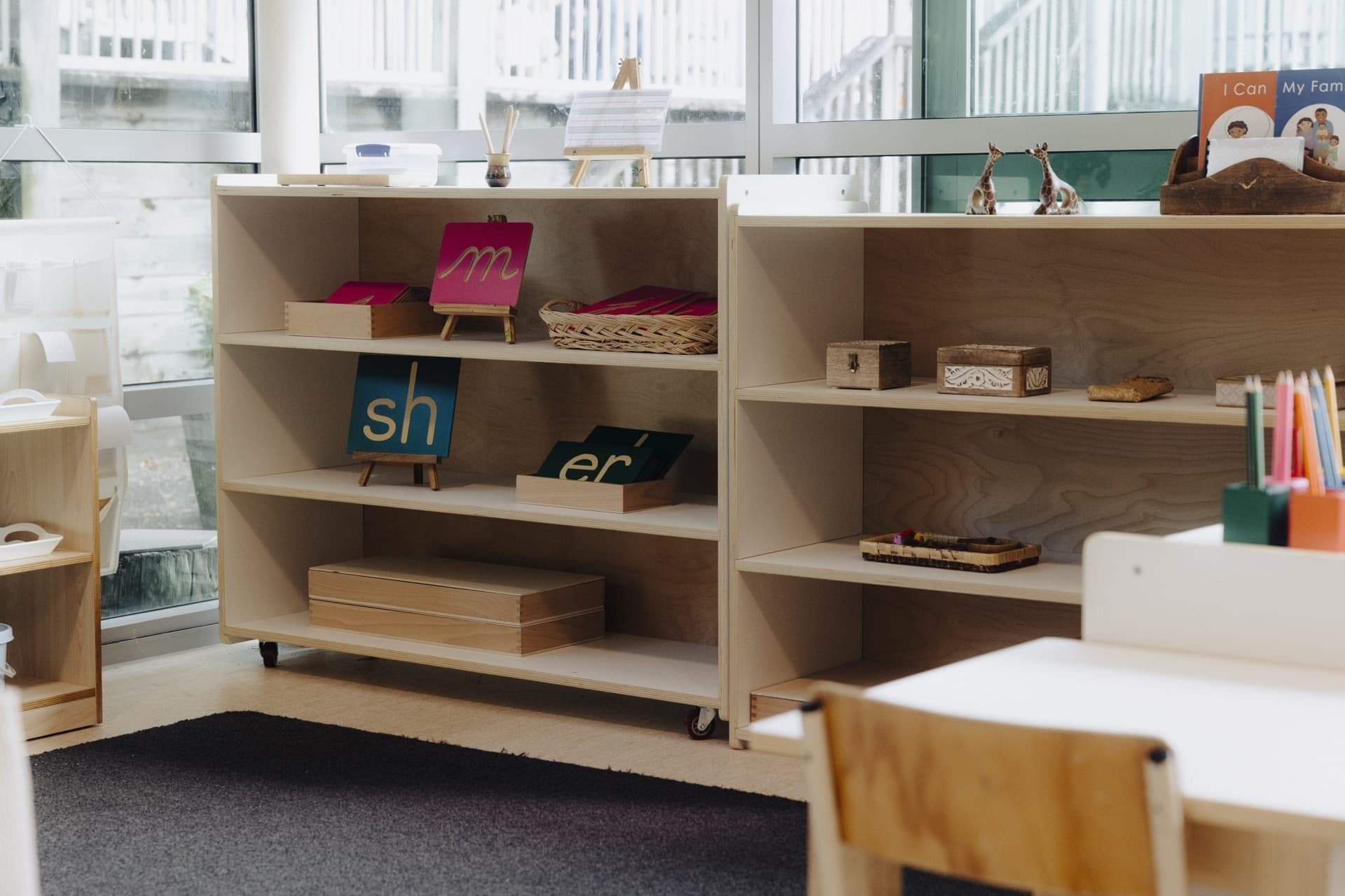 Classroom shelves with Montessori language and practical life materials at Triton Montessori Educare