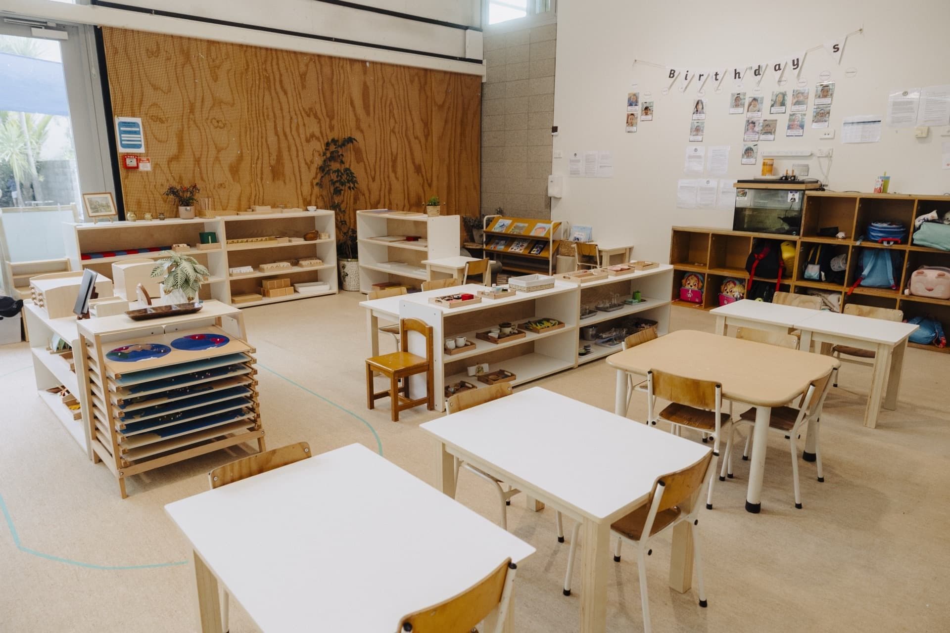 Bright Montessori classroom at Triton Montessori Educare with child-sized tables and prepared shelves
