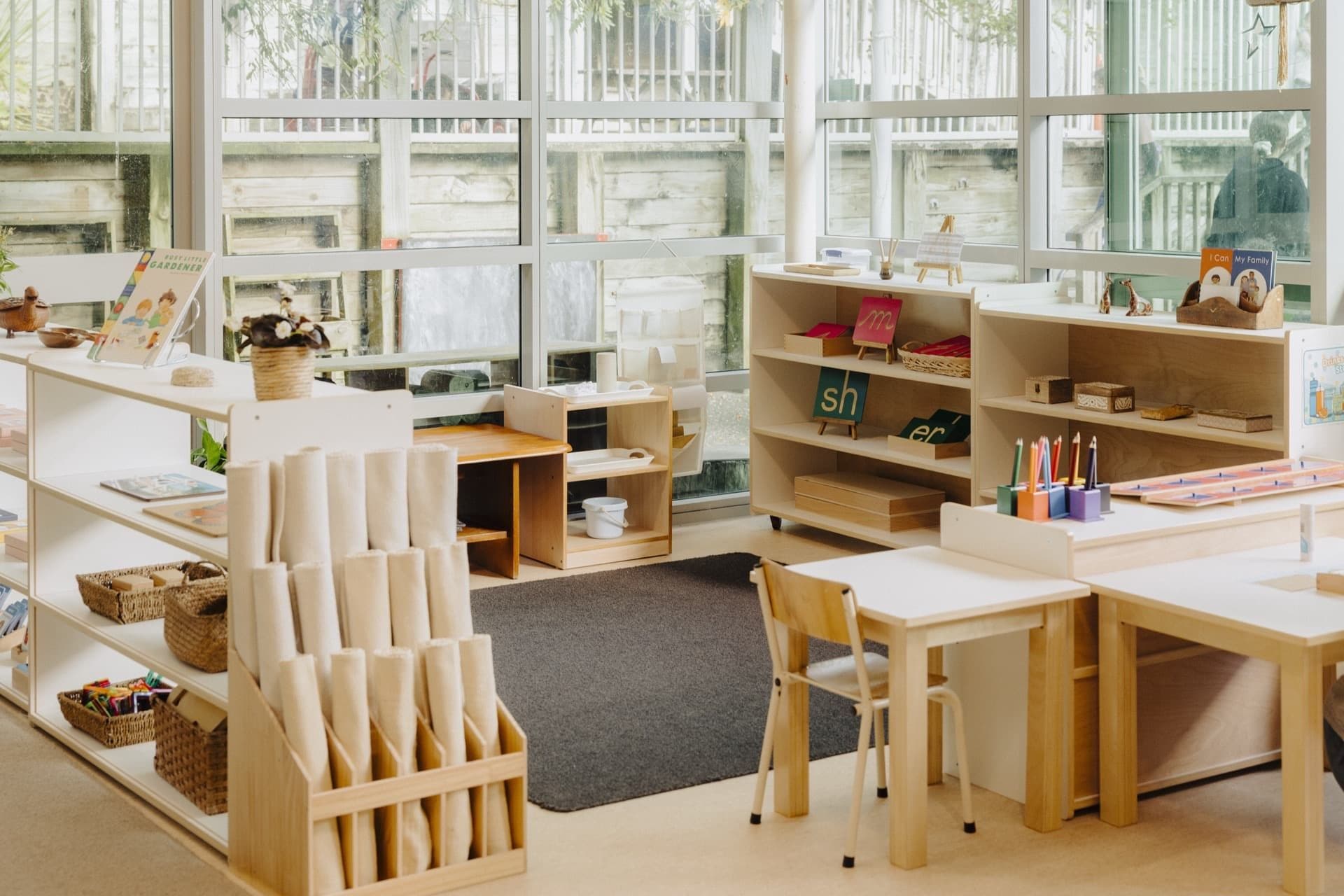 Prepared Montessori classroom with shelves, tables and natural light at Triton Montessori Educare