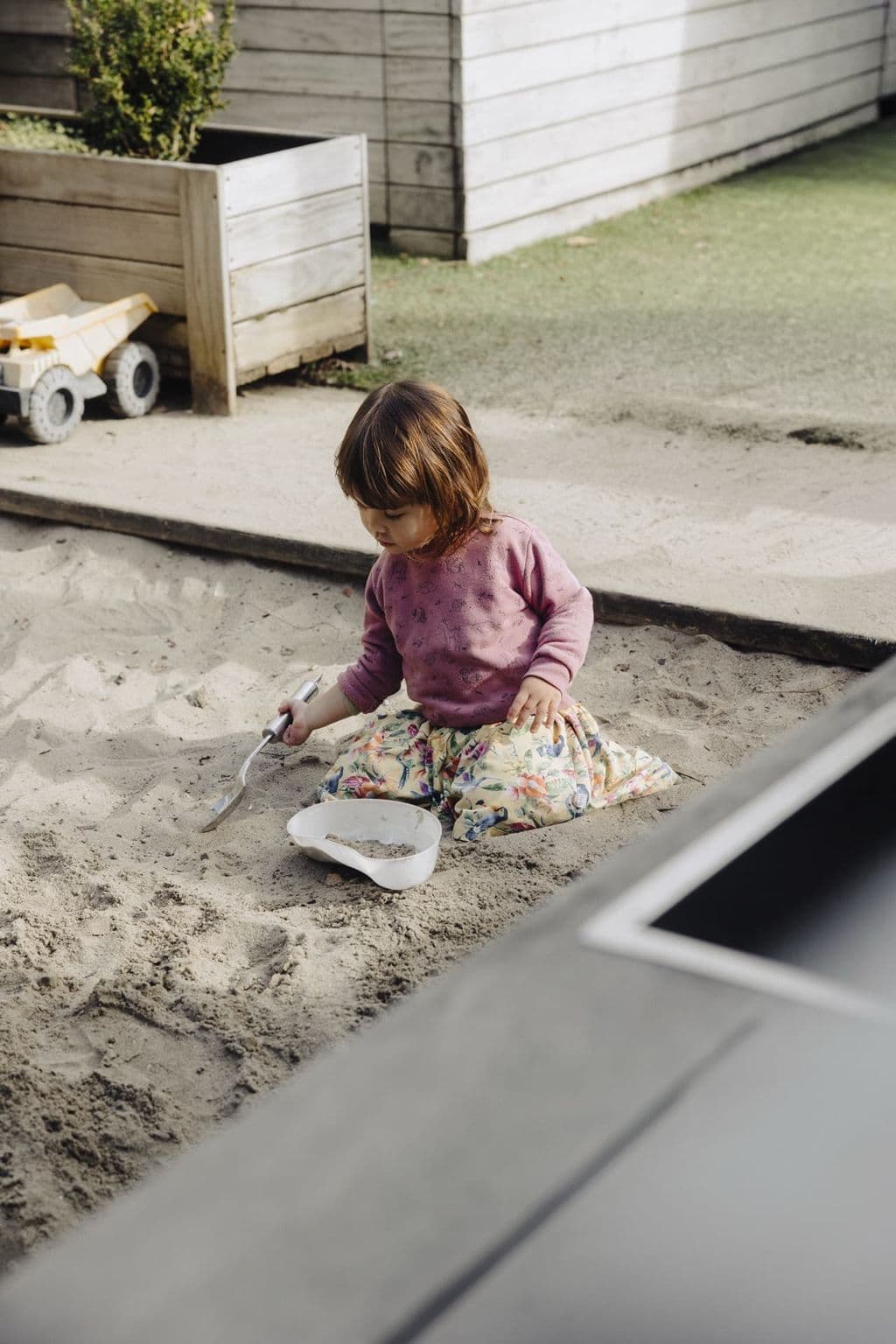 Children digging and exploring in the outdoor sandpit at Triton Montessori Educare